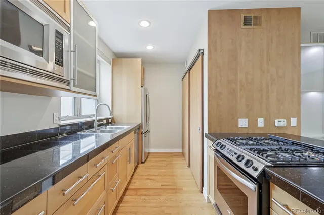 a kitchen with stainless steel appliances granite countertop a stove and a sink