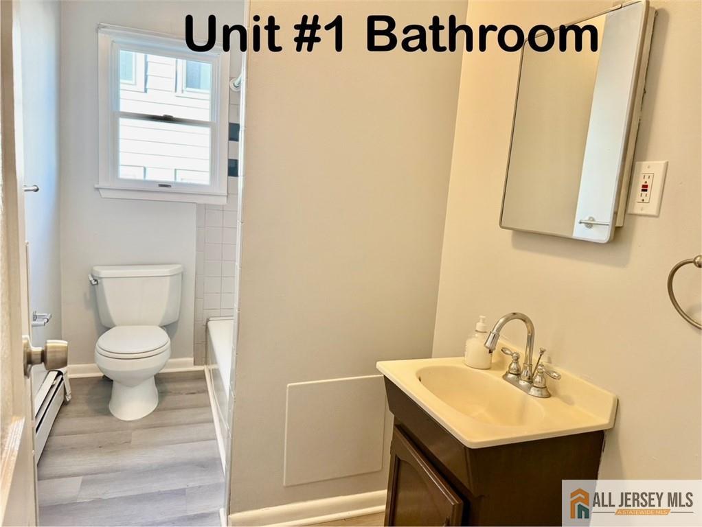 74 Andrew Street Hamilton, NJ 08610 - Photo 11 of 13 a bathroom with a sink a mirror and a toilet