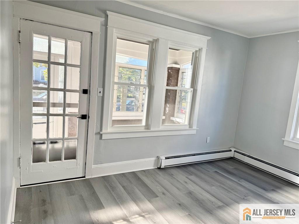 74 Andrew Street Hamilton, NJ 08610 - Photo 4 of 13 an empty room with wooden floor and windows
