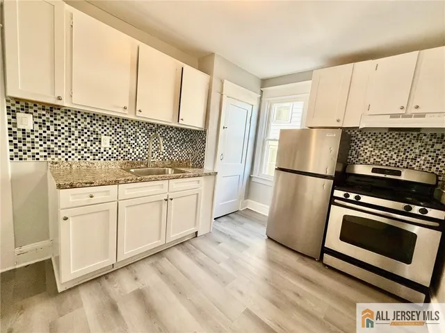 a kitchen with white cabinets and white appliances