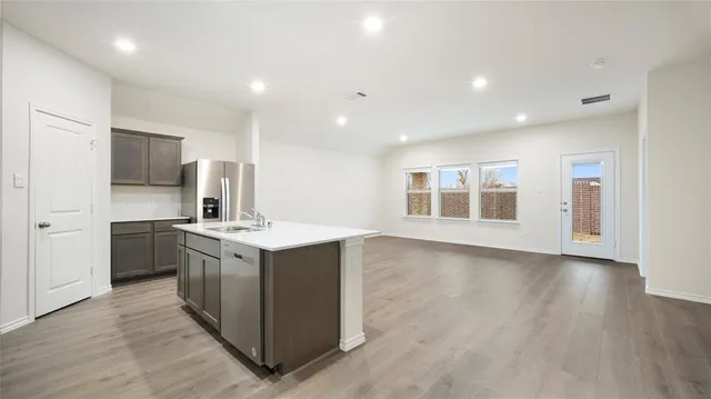 a kitchen with stainless steel appliances a refrigerator and a stove top oven