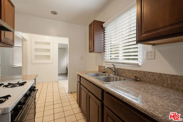 a kitchen with granite countertop a sink stove and cabinets