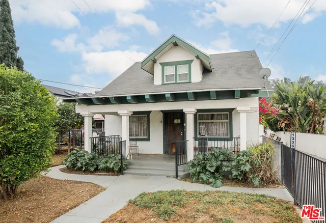 a front view of a house with a yard and potted plants