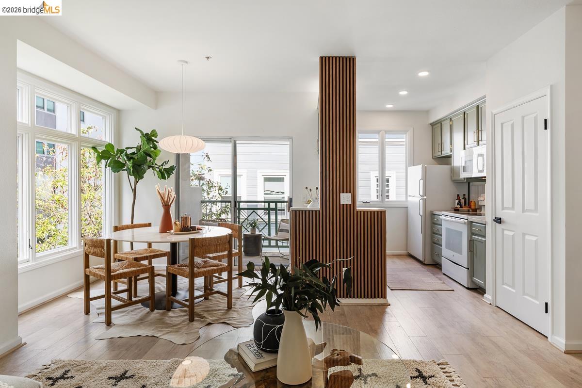 2029 Channing Way, Unit 3D Berkeley, CA 94704 - Photo 8 of 54 Open-concept living area featuring wood-finish flooring, recessed lighting, a private balcony, and a kitchen with light green cabinetry and white appliances