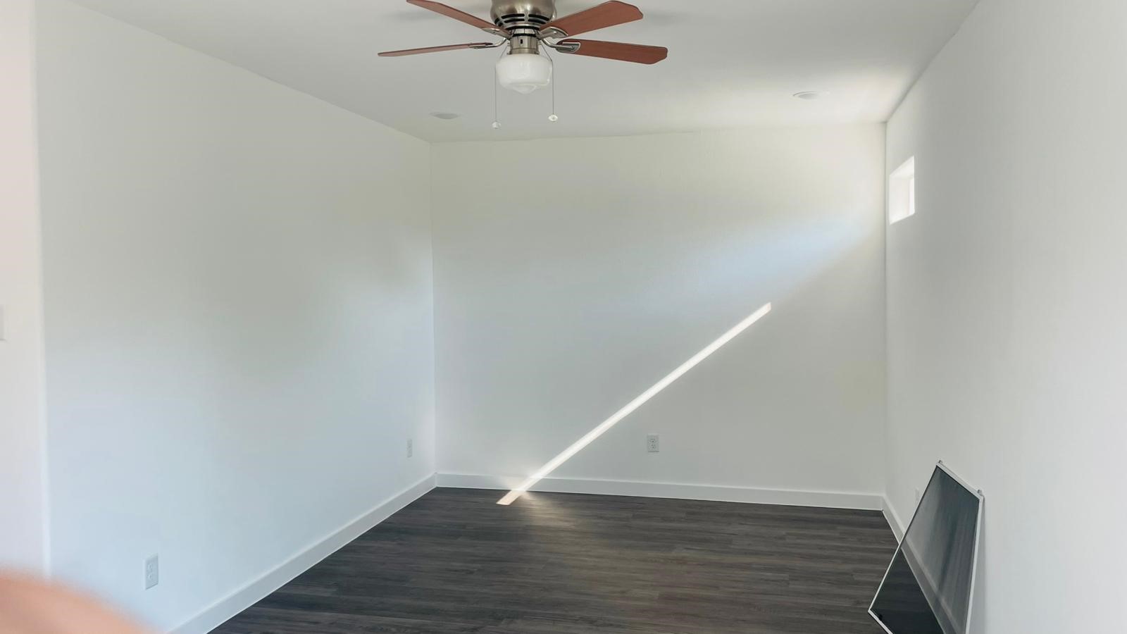 8414 Sandra Street, Unit A Houston, TX 77016 - Photo 12 of 14 a view of an empty room with wooden floor and a ceiling fan
