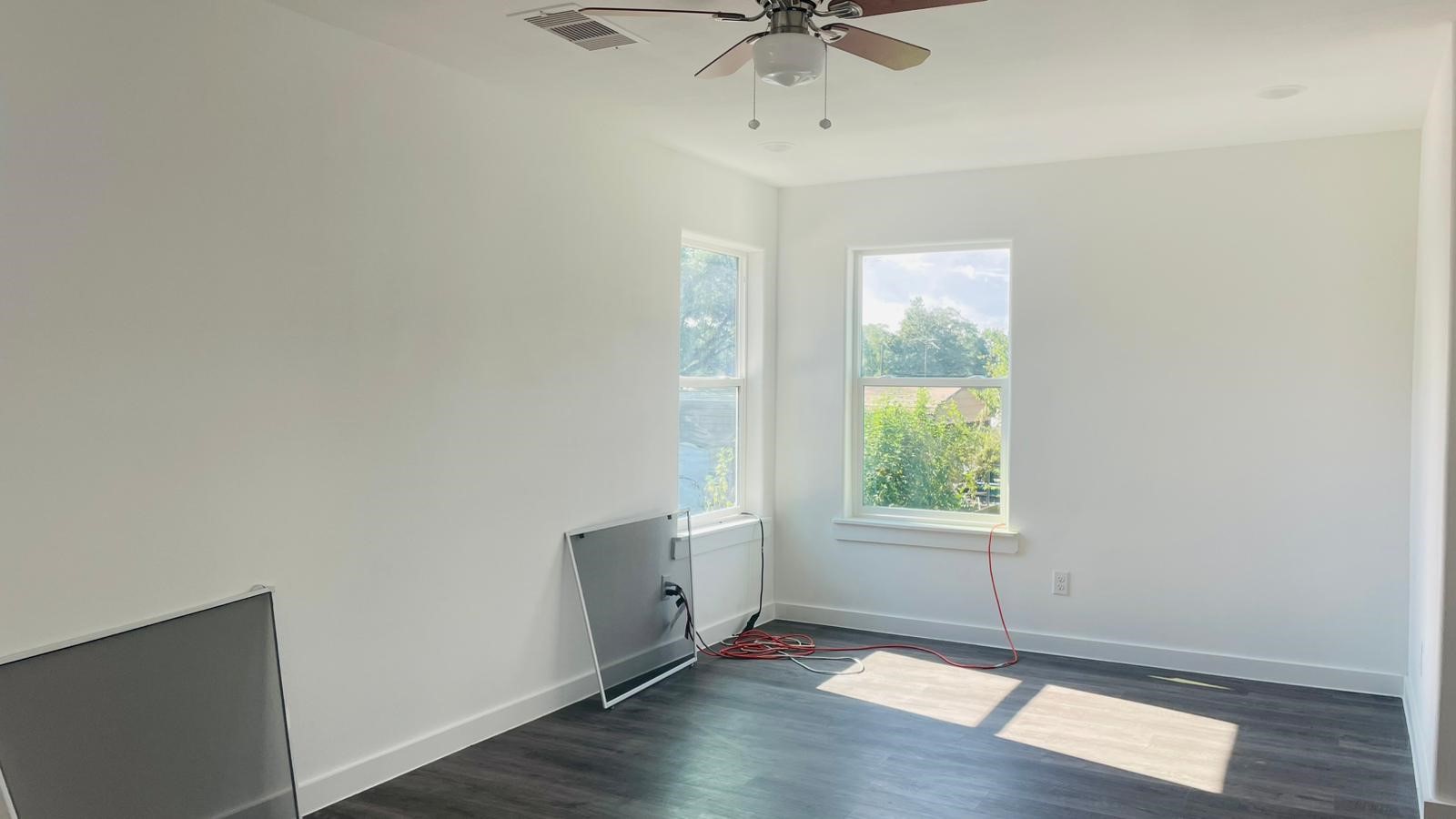 8414 Sandra Street, Unit A Houston, TX 77016 - Photo 5 of 14 an empty room with wooden floor fan and windows