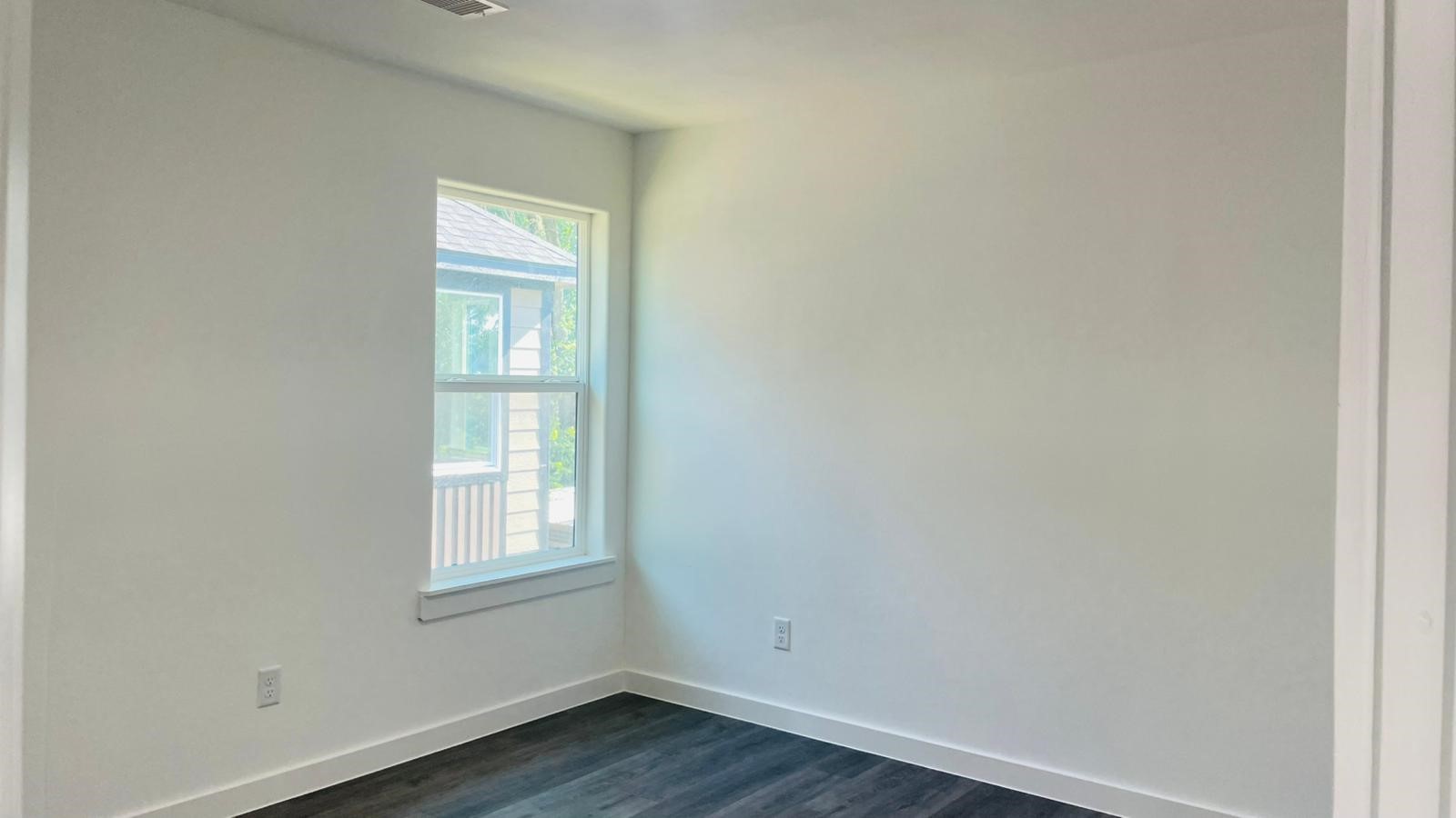 8414 Sandra Street, Unit A Houston, TX 77016 - Photo 7 of 14 an empty room with wooden floor and windows