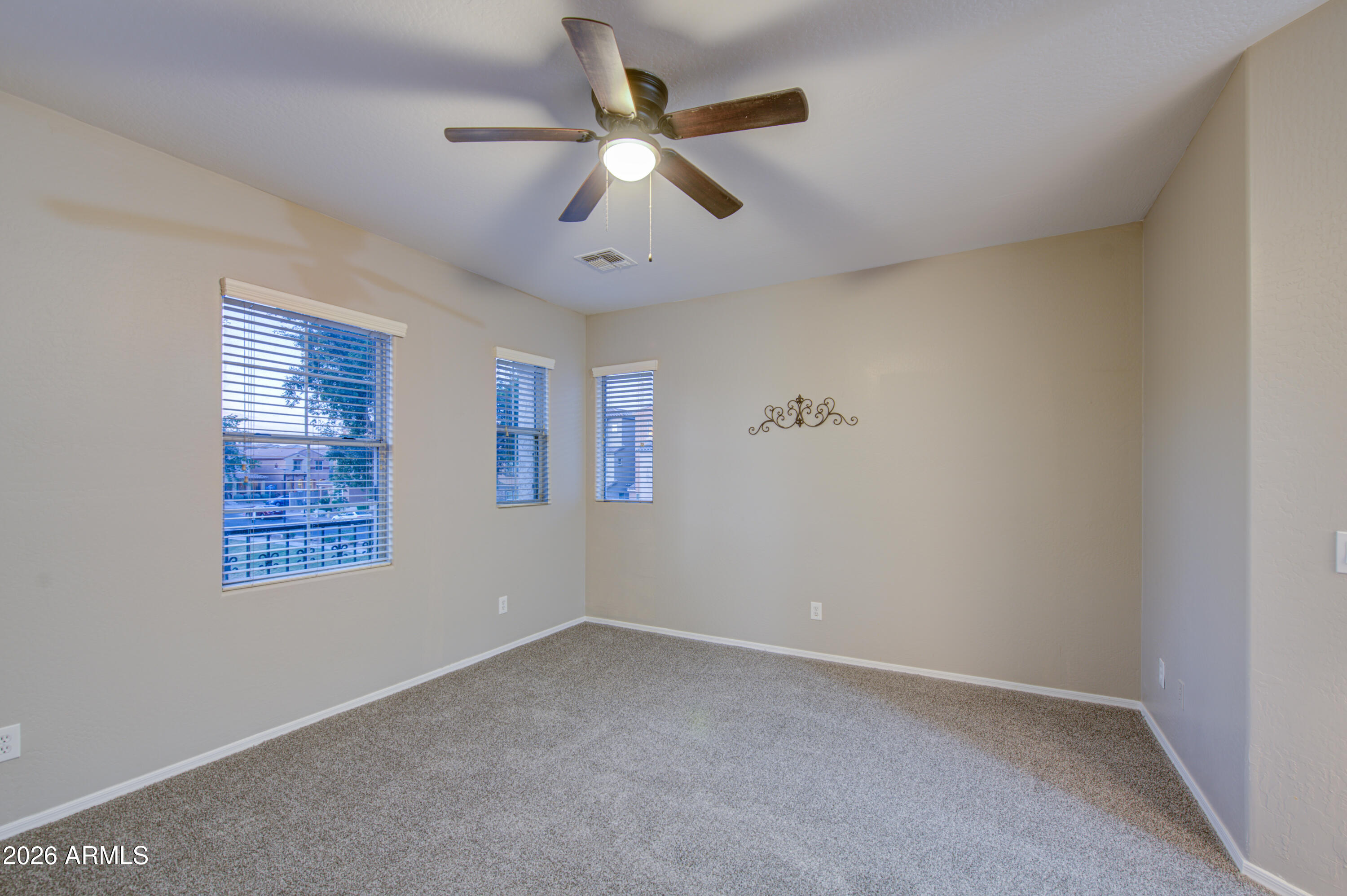 7759 West Monte Vista Road Phoenix, AZ 85035 - Photo 20 of 43 an empty room with a ceiling fan and windows
