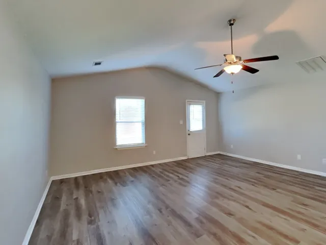 wooden floor in an empty room with a window