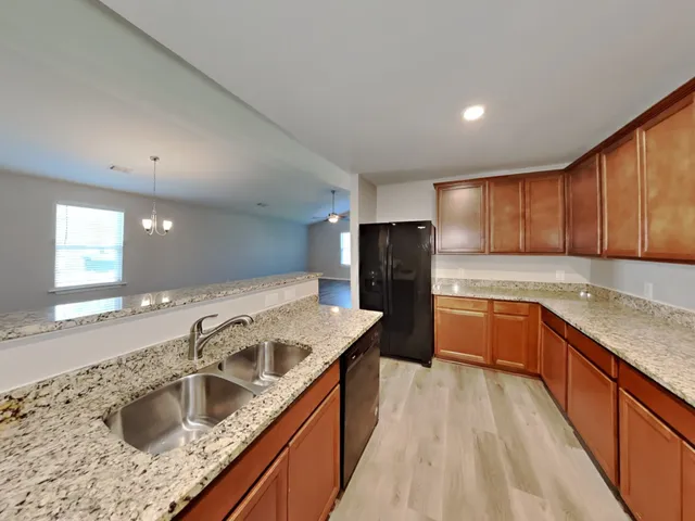 a kitchen with stainless steel appliances granite countertop a sink stove and refrigerator
