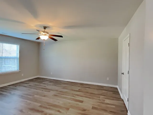 wooden floor in an empty room with a window