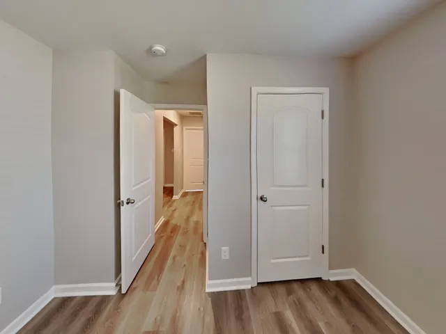 a view of a hallway with wooden floor and closet