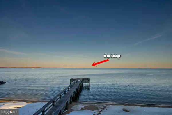 a view of a lake in between two large trees