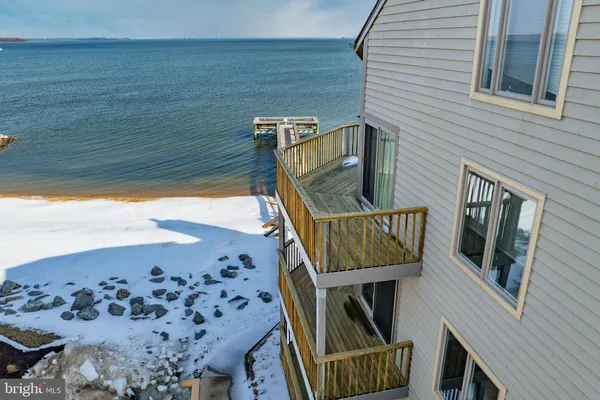 a kitchen with stainless steel appliances a sink a stove a refrigerator cabinets and chairs