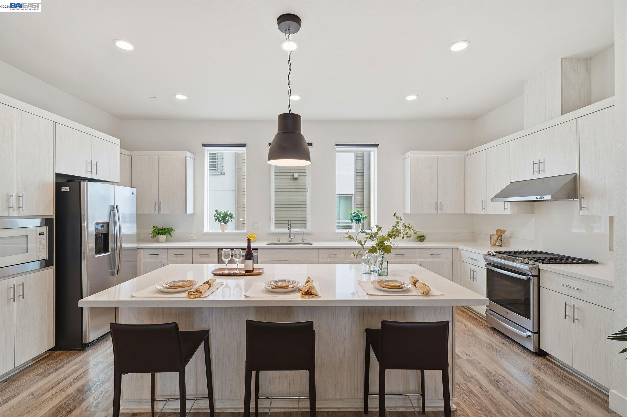7906 Regional Common Dublin, CA 94568 - Photo 12 of 40 a kitchen with stainless steel appliances a dining table chairs stove refrigerator and cabinets