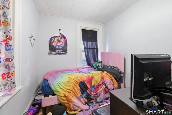 a bedroom with a bed and a television