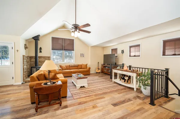 a living room with furniture a flat screen tv and a window