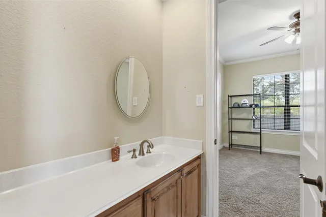 a bedroom with a bed next to a window with a flat tv screen and a dresser