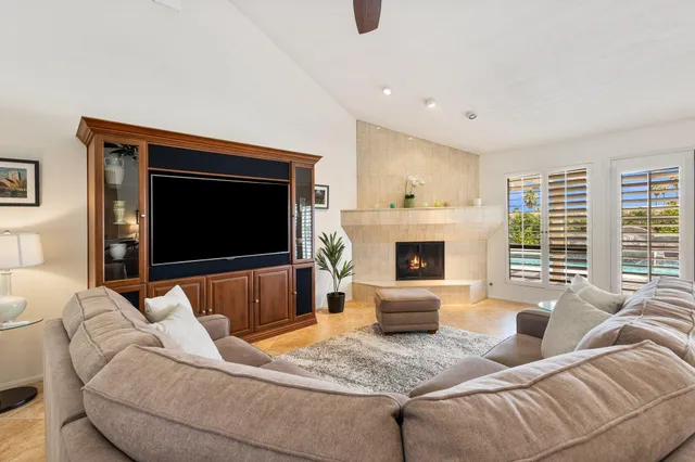 a living room with furniture a flat screen tv and a fireplace