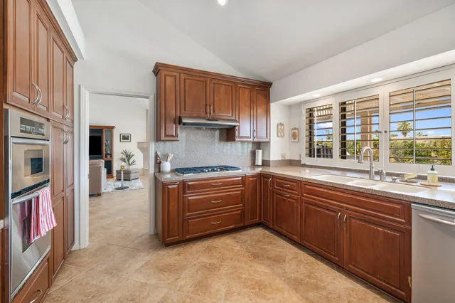 a kitchen with stainless steel appliances granite countertop a stove a sink and a refrigerator