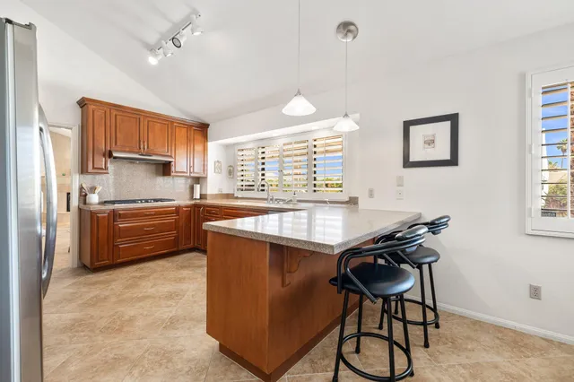 a kitchen with kitchen island a counter top space appliances and a window