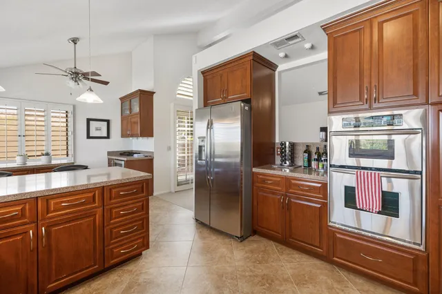 a kitchen with stainless steel appliances granite countertop a refrigerator and a stove top oven
