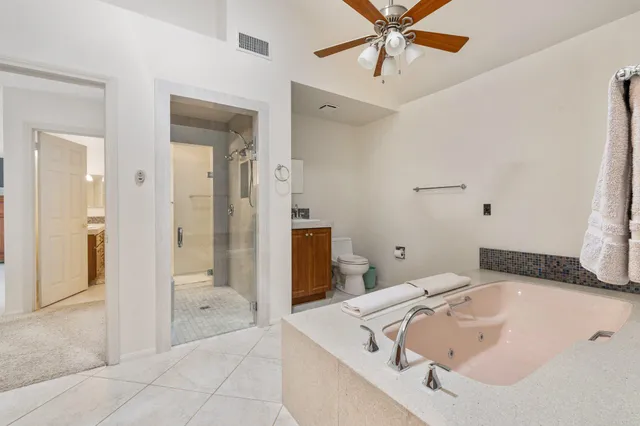 a bathroom with a tub sink and mirror
