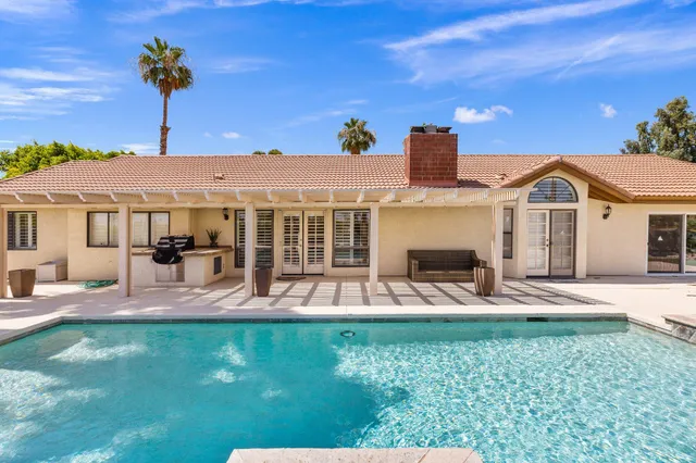a view of a house with a yard fire pit and a patio