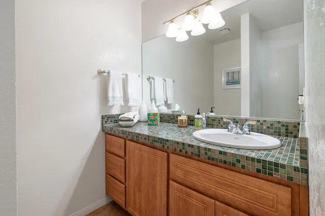 a spacious bathroom with a granite countertop sink a toilet and a mirror