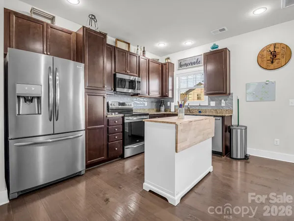 a kitchen with stainless steel appliances granite countertop a refrigerator stove and microwave