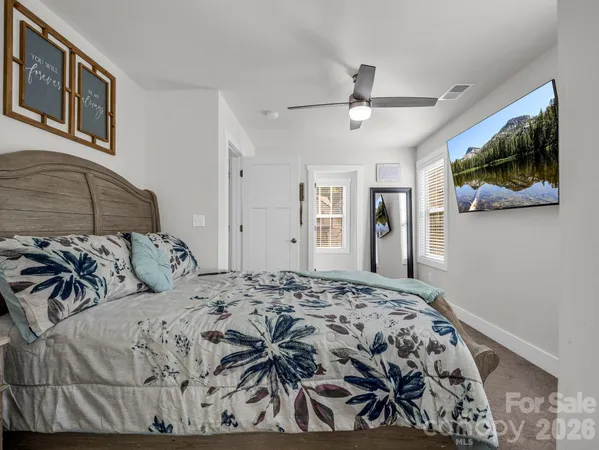 a bedroom with a large bed and a chandelier