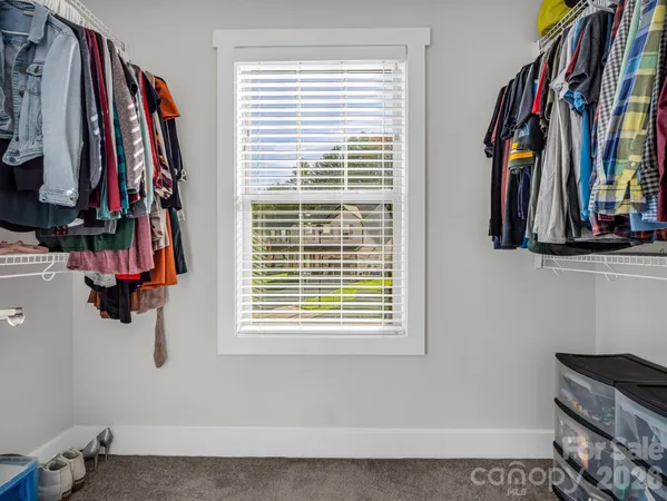 a view of walk in closet with clothes and shoes