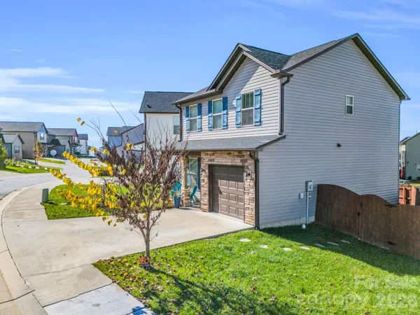a front view of a house with a garden and trees