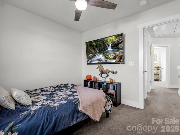 a bedroom with a bed and a painting on the wall