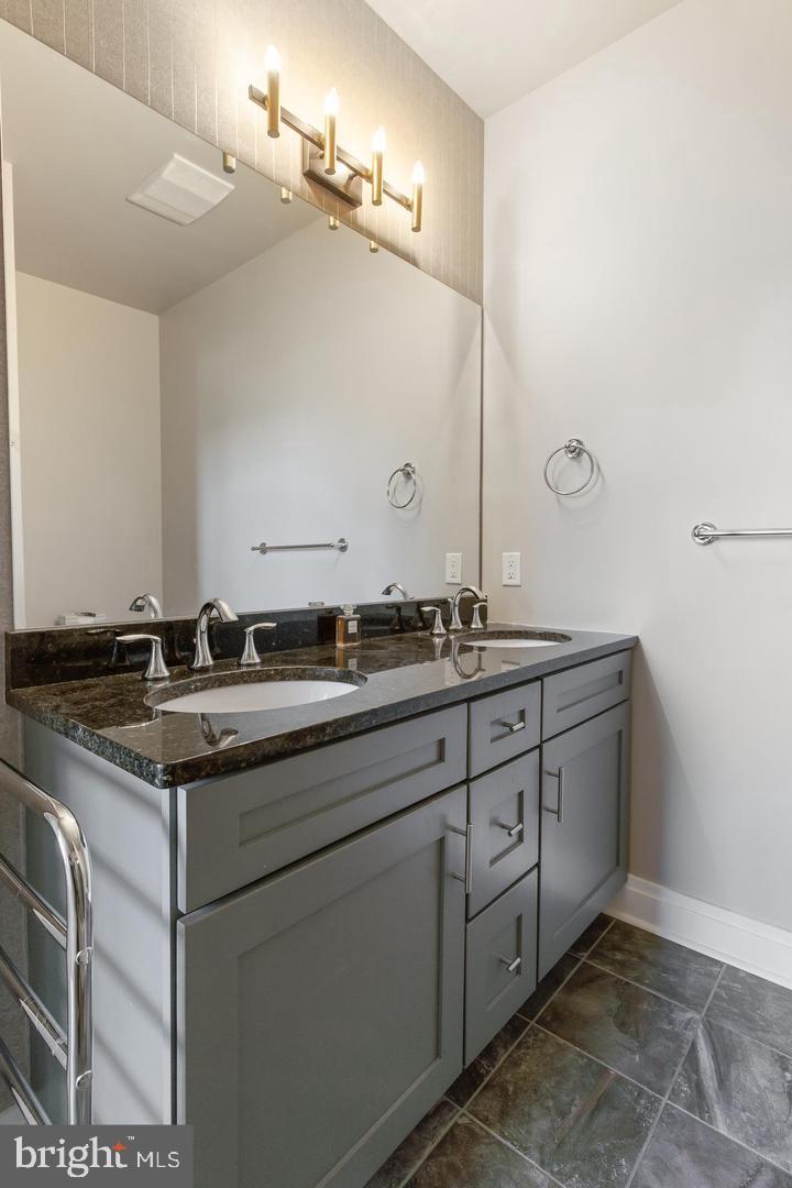41 West Lemon Street, Unit 401 Lancaster, PA 17603 - Photo 14 of 22 a bathroom with a granite countertop sink and a mirror