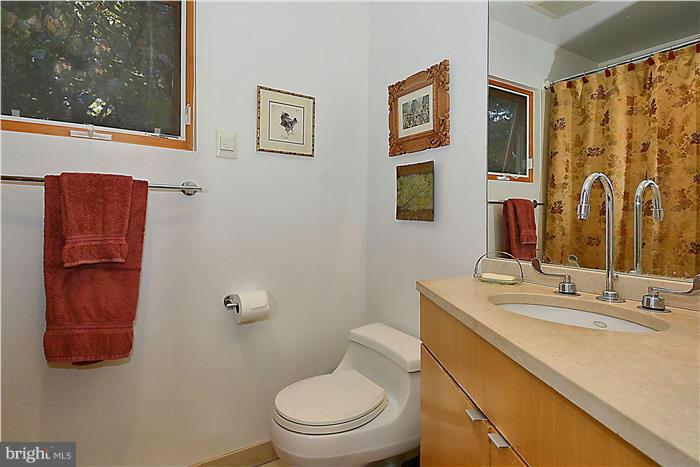 9206 Saybrook Avenue Silver Spring, MD 20901 - Photo 19 of 30 a bathroom with a toilet sink and mirror