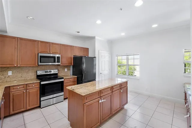 a kitchen with stainless steel appliances granite countertop a stove microwave and sink