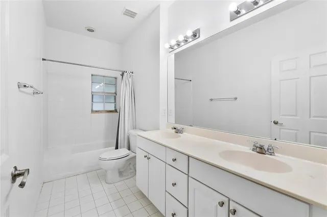 a bathroom with a double vanity sink toilet mirror and shower