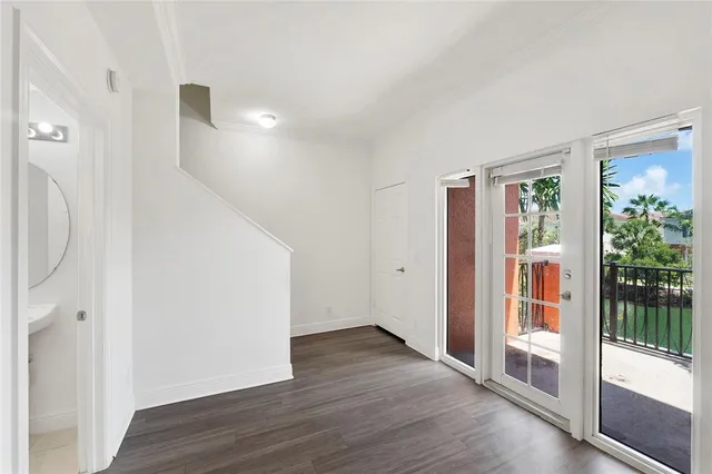 a view of a hallway with wooden floor and entryway