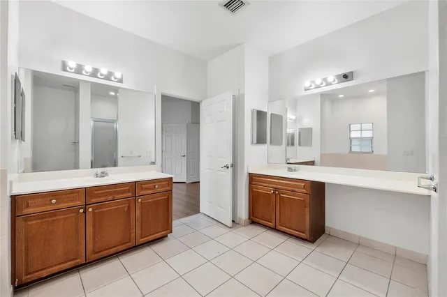 a spacious bathroom with a granite countertop double vanity sink mirror and bathtub