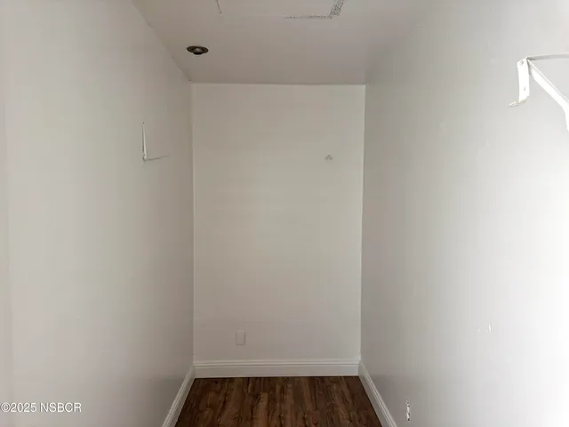 a view of walk in closet with wooden floor