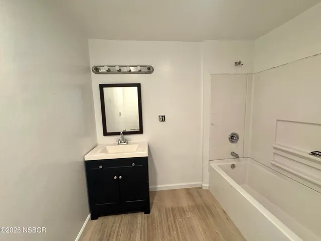 a bathroom with a tub sink and mirror