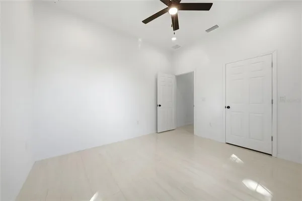 an empty room with a ceiling fan and window
