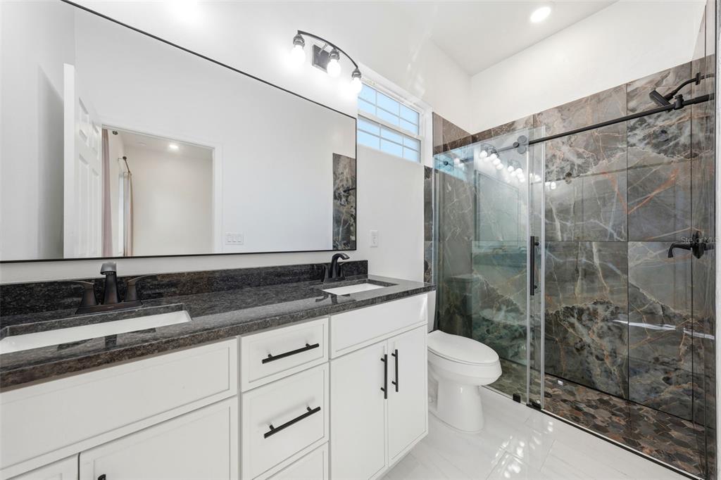 620 Titcomb Street Eustis, FL 32726 - Photo 22 of 30 a bathroom with a double vanity sink toilet mirror and shower