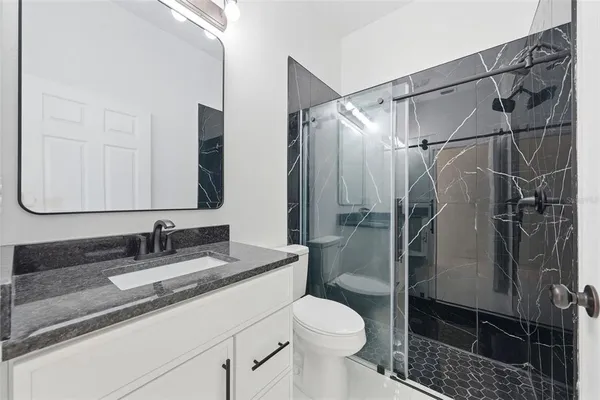 a bathroom with a sink toilet and shower