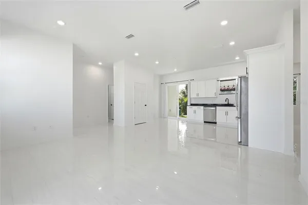 a view of kitchen with refrigerator stove and white cabinets