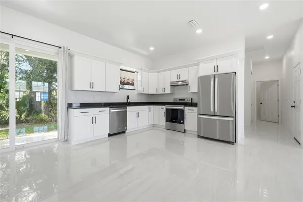 a kitchen with stainless steel appliances granite countertop a refrigerator sink and cabinets