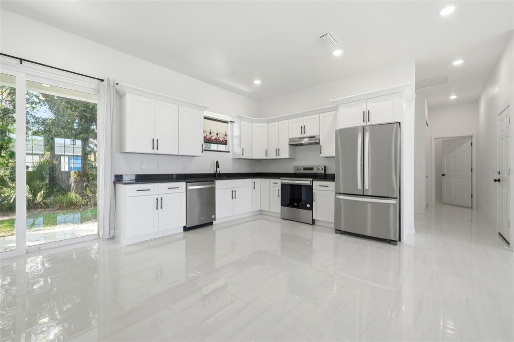 620 Titcomb Street Eustis, FL 32726 - Photo 9 of 30 a kitchen with stainless steel appliances granite countertop a refrigerator sink and cabinets