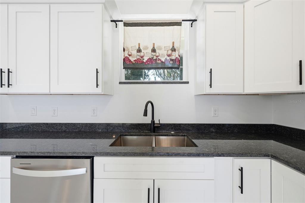 620 Titcomb Street Eustis, FL 32726 - Photo 10 of 30 a kitchen with stainless steel appliances granite countertop white cabinets sink and a window