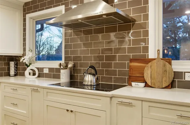 a bathroom with a granite countertop white vanity a window and a mirror